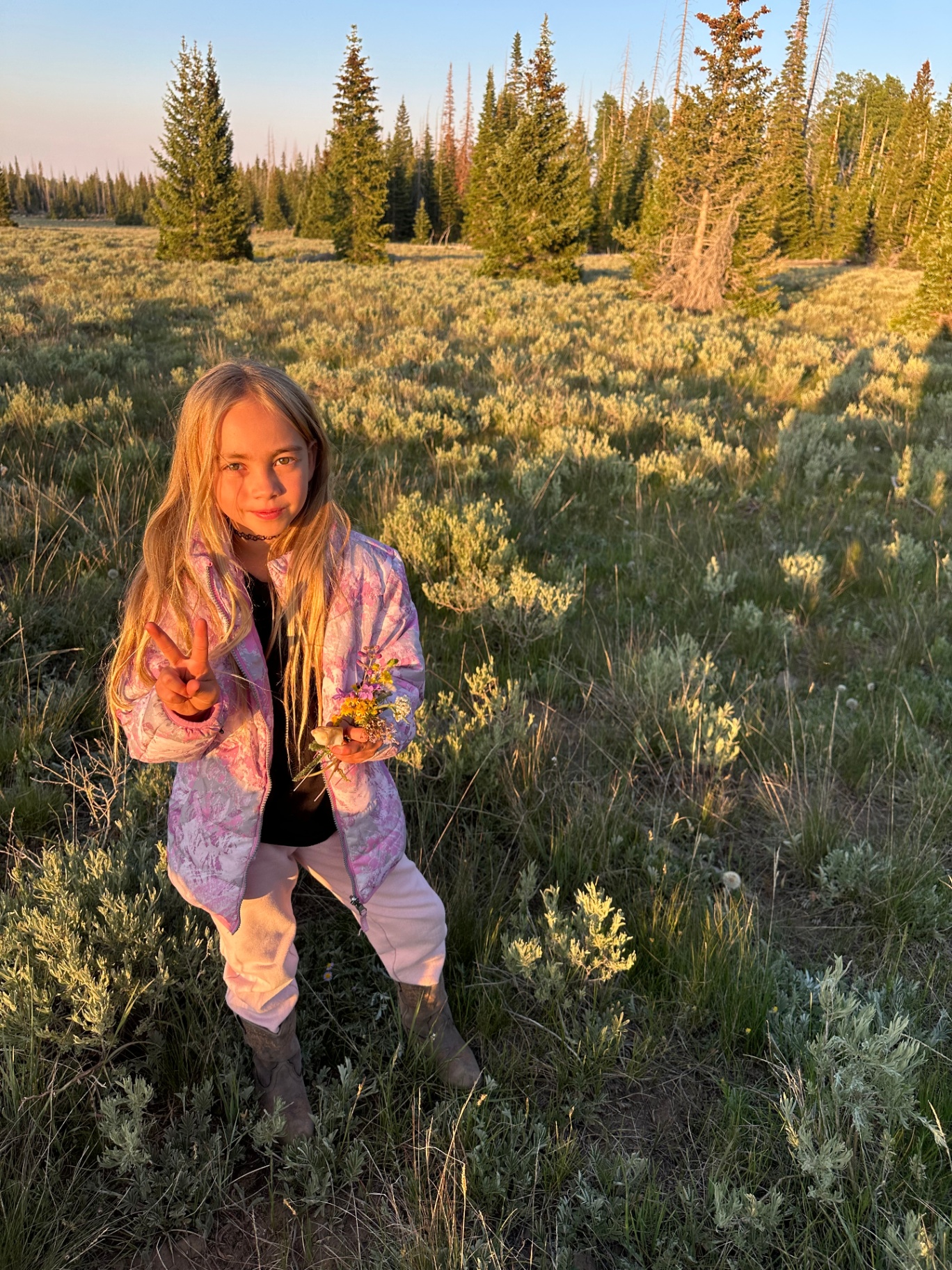 London 'Lolo' in a sunlit field holding wildflowers